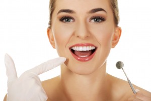 Young happy woman checking her teeth whith dental mirror,isolated on white